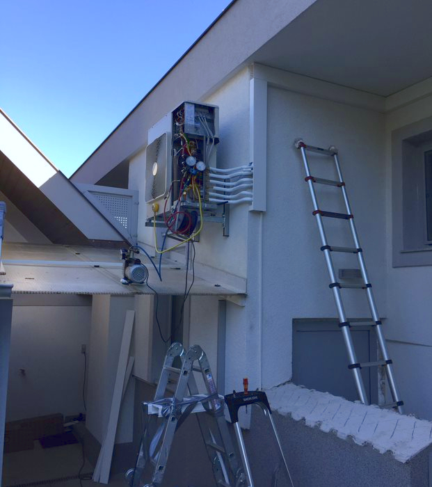 Abkühlung - Außengerät ohne Abdeckung an Hauswand neben Leiter