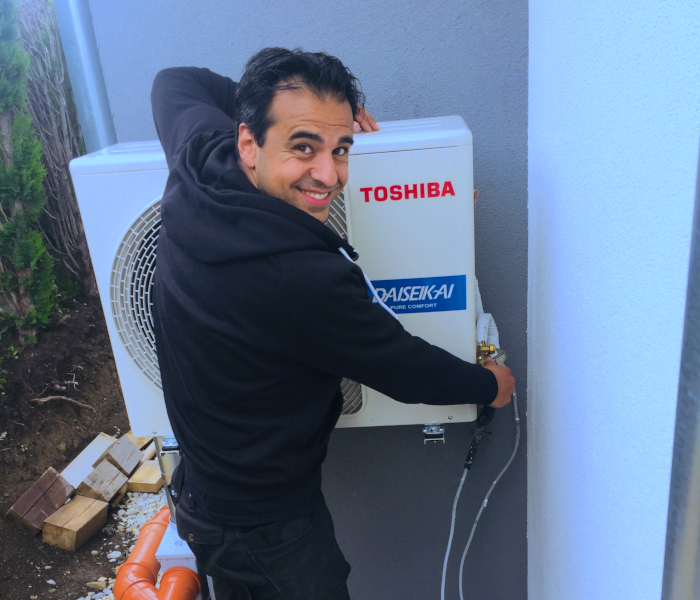Abkühlung - Hani Ghasemi arbeitet an Klimaanlage und lacht in Kamera
