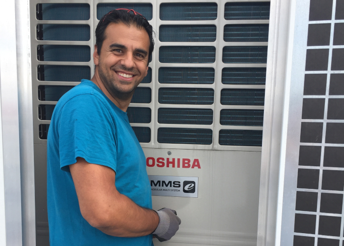 Abkühlung - Hani Ghasemi arbeitet an Klimaanlage und lacht in Kamera