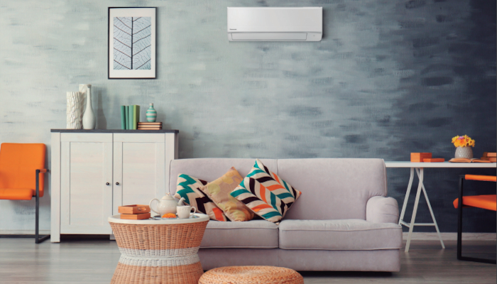 Panasonic Klimaanlagen in Wohnzimmer ober weißer Couch an dunkler Wand
