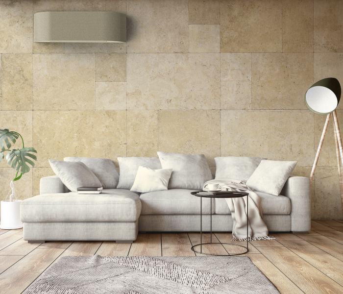 Toshiba Klimaanlagen - Wandgerät oberhalb von beigem Sofa mit vielen Pölstern in Wohnzimmer