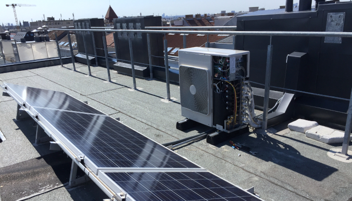 Abkühlung - Klima-Außengerät auf Dach ohne Abdeckung neben Solarzellen